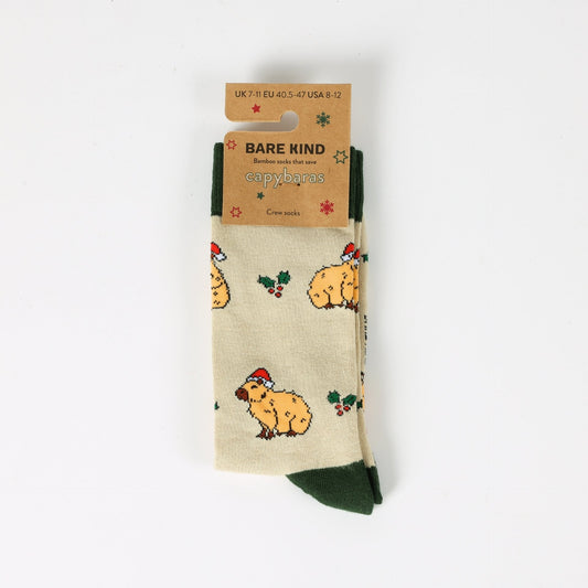 Beige socks with capybara pattern and 'Bare Kind' packaging on a white background