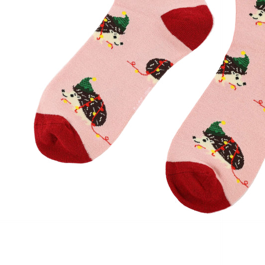 Pair of socks with festive hedgehogs design on a pink background