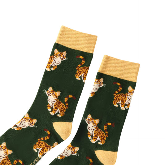 Green socks with leopard pattern and yellow cuffs and toes on a white background