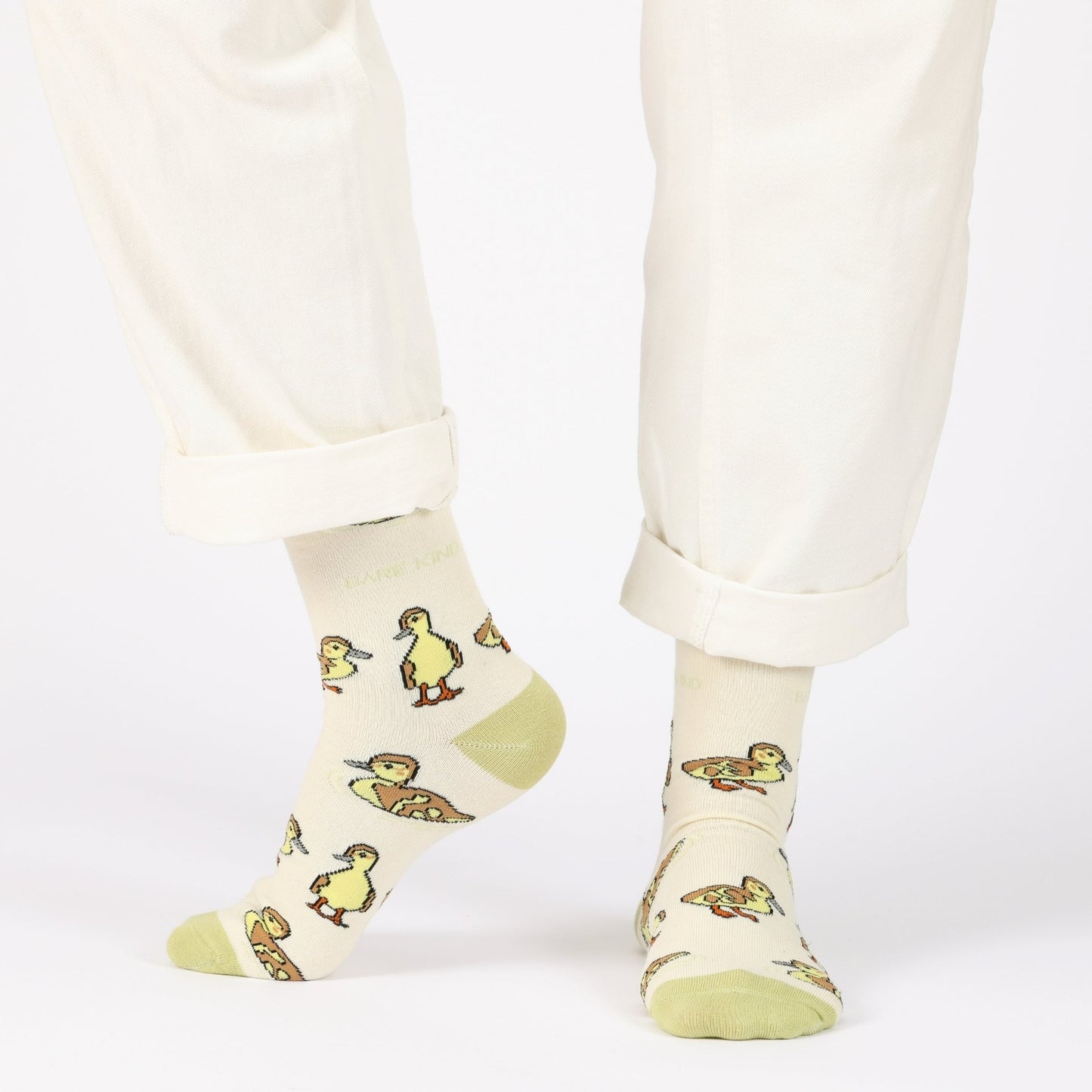 model with white trousers wearing green ducklings bamboo socks
