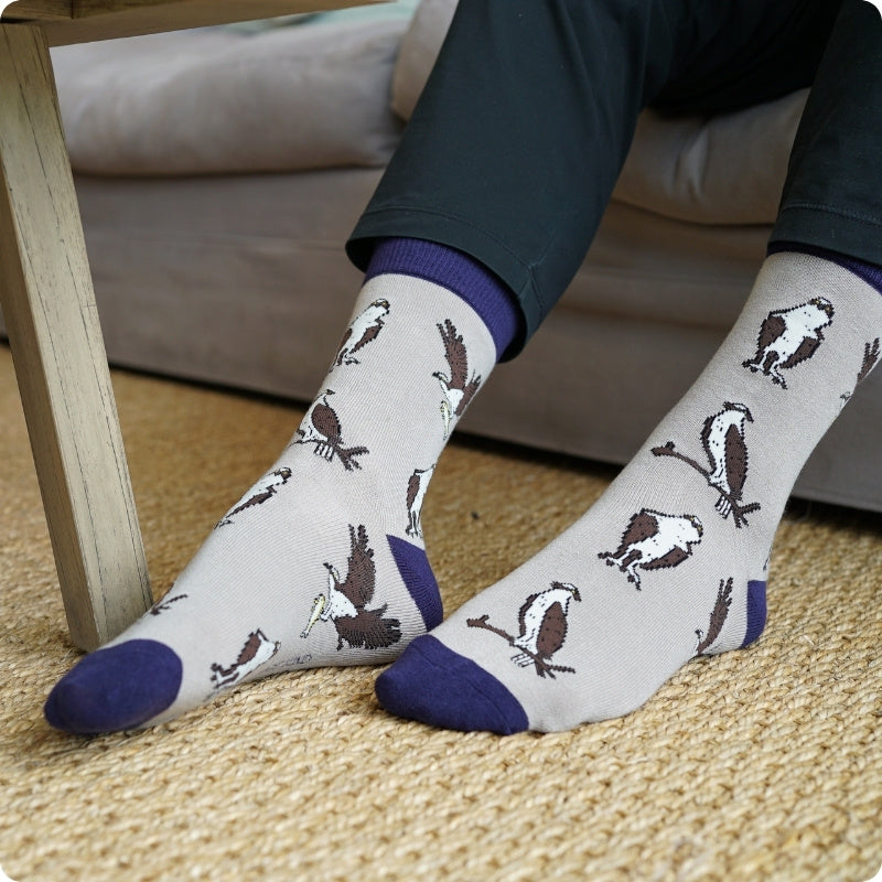 Person wearing Osprey bamboo socks on a carpeted floor.