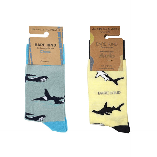 Two pairs of socks with shark and orca design packaging, one in blue and one in yellow, on a white background.