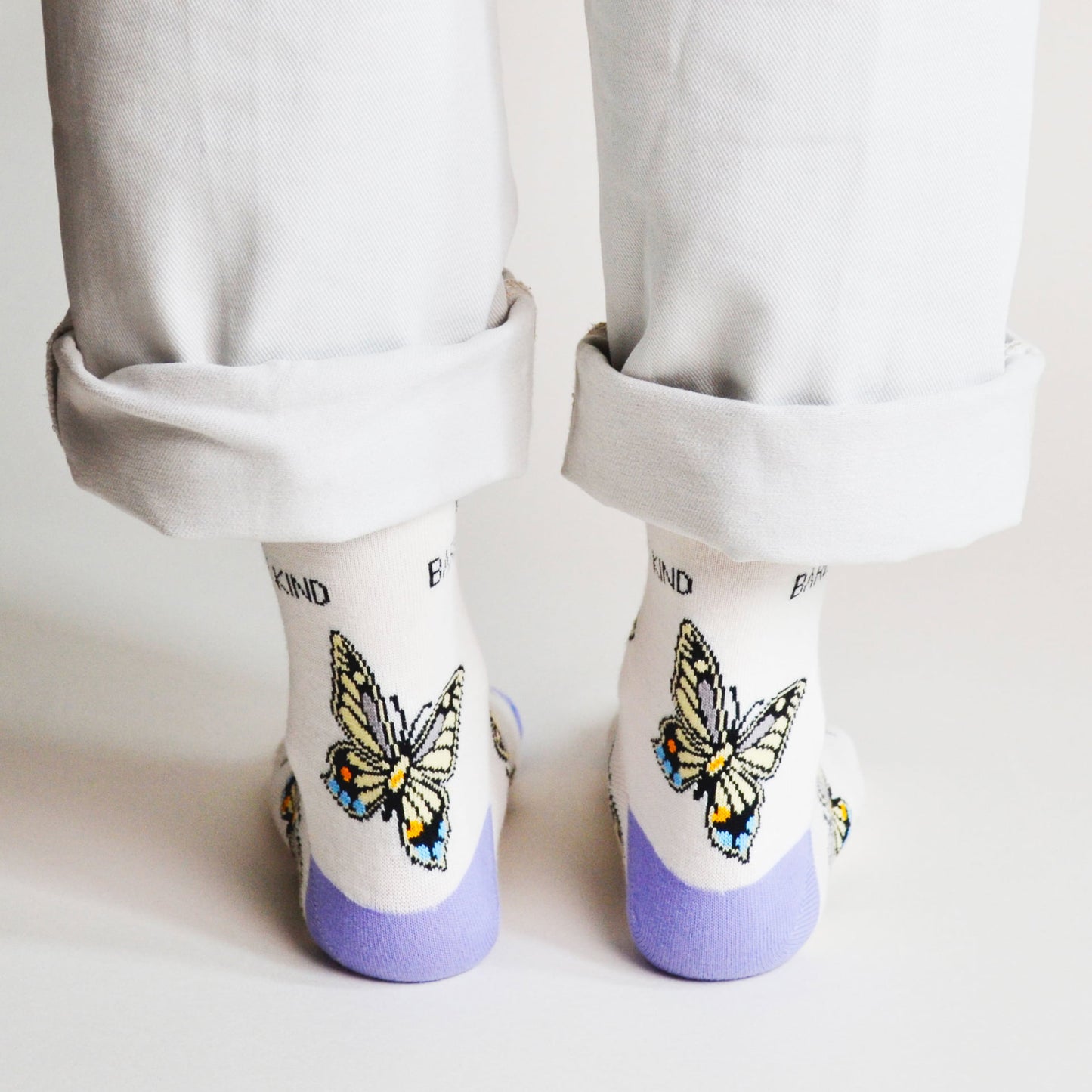 rear view of standing model wearing bamboo socks featuring butterfly