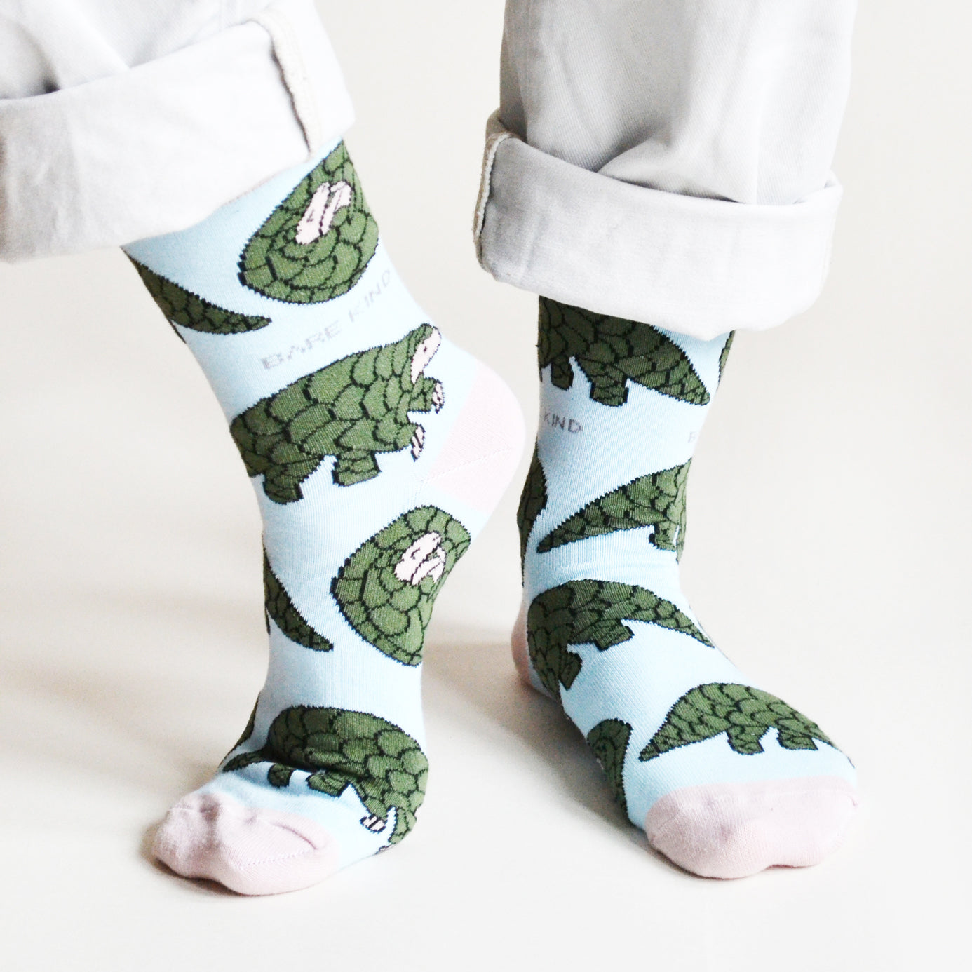 front view of standing model wearing pastel blue pangolin socks with the right heel lifted