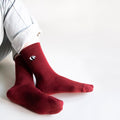 sitting model with ankles crossed wearing ruby red panda ribbed bamboo socks