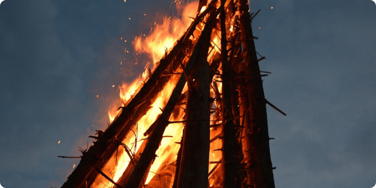 Fire burning on a wooden structure against a dark sky