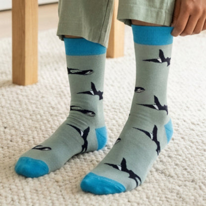 Person wearing socks with orca pattern on a carpeted floor