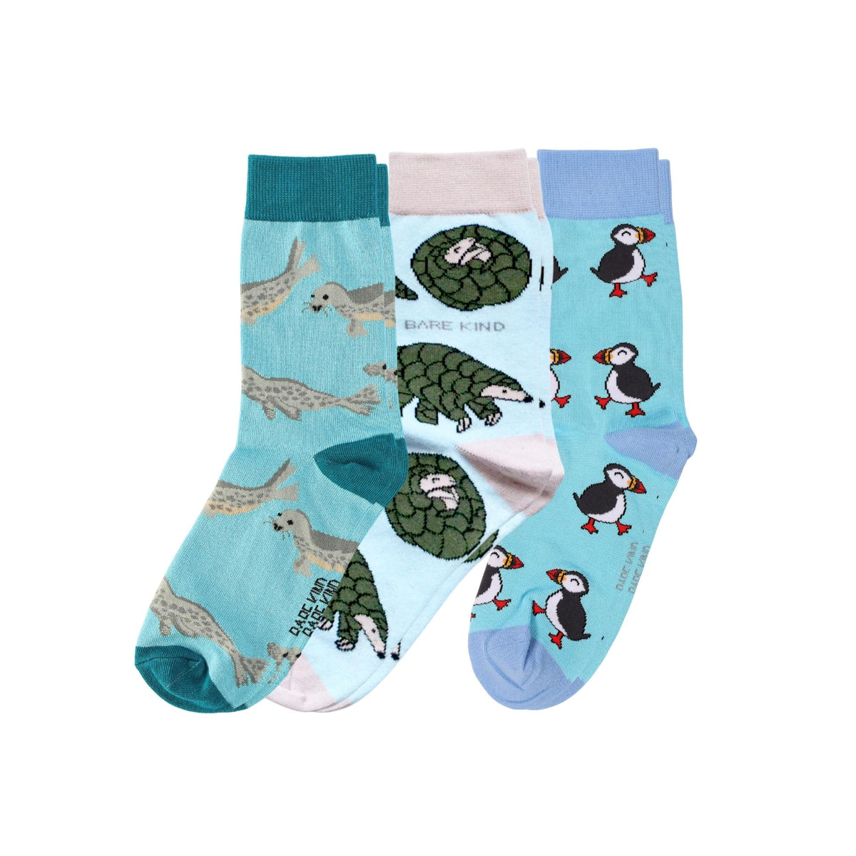 Three pairs of crew socks with animal prints, including puffin, pangolin, and seal, displayed against a plain white background.