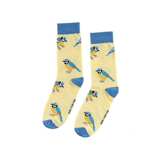 A pair of crew socks with a pale yellow background printed with blue tits, featuring solid blue cuffs, heels, and toes. 