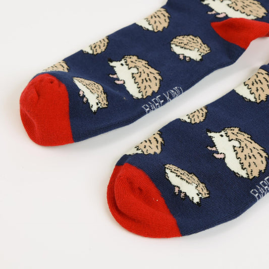 Navy socks with beige hedgehog pattern and red toes on a white background