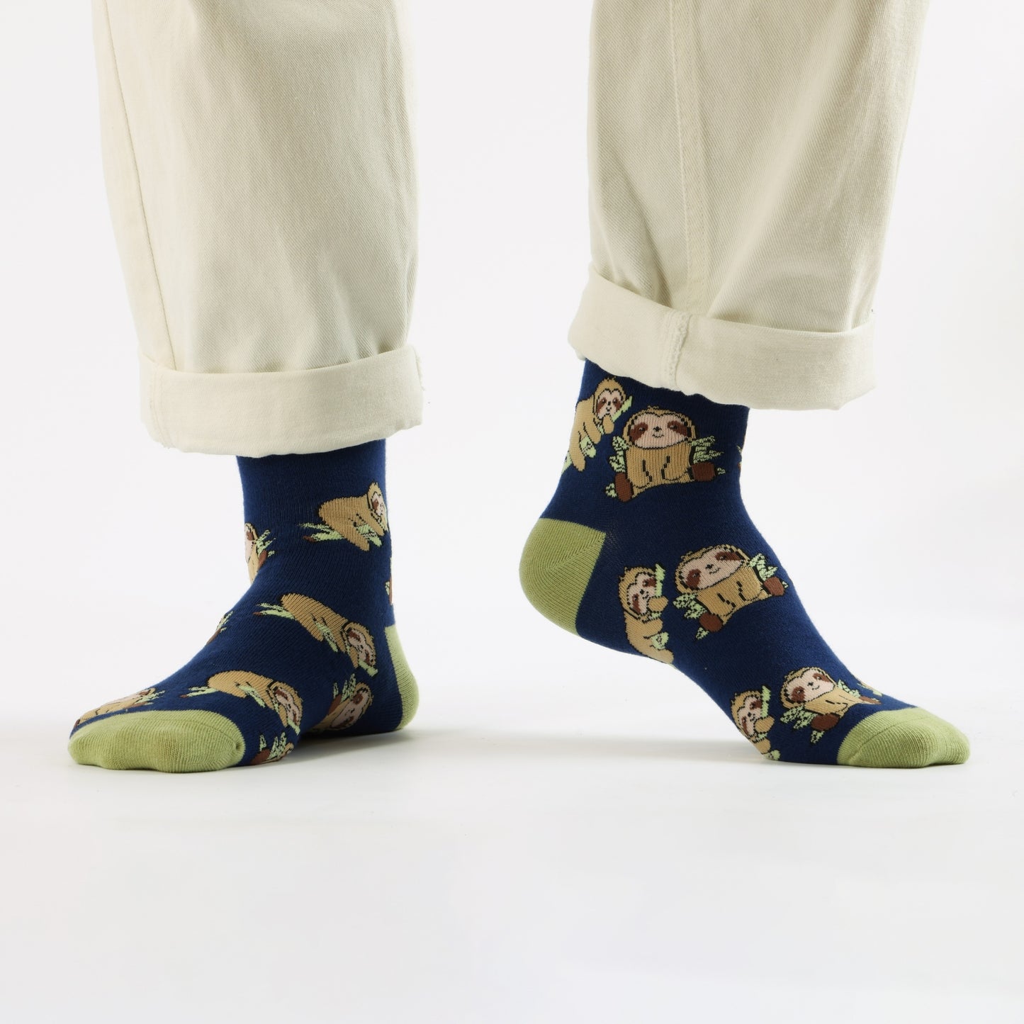 blue sloth bamboo socks worn by a person in beige pants on a white background
