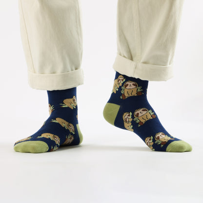 blue sloth bamboo socks worn by a person in beige pants on a white background