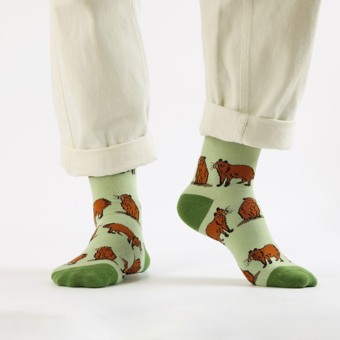 Green capybara bamboo sock worn by a person on a white background
