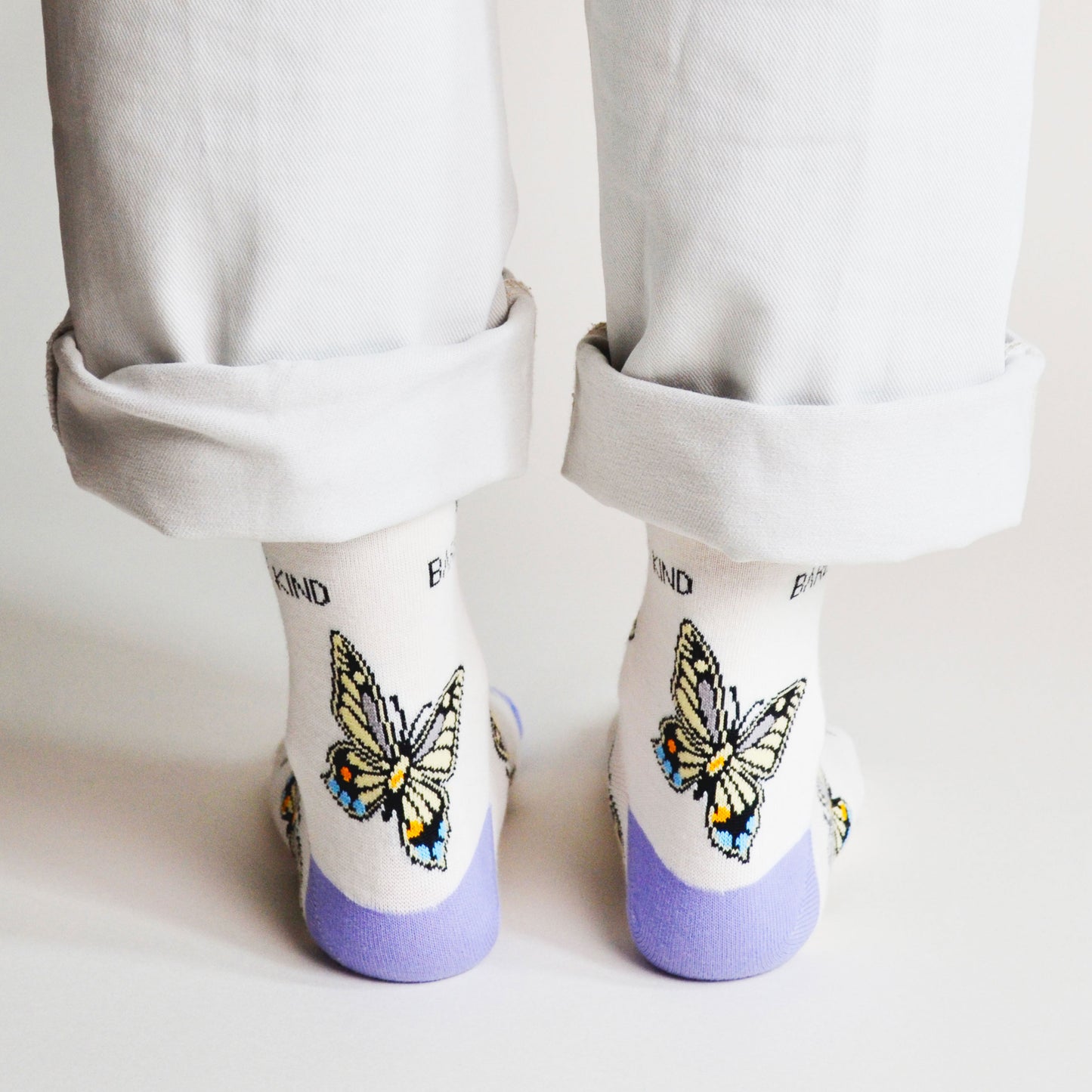 rear view of standing model wearing bamboo socks featuring butterfly design