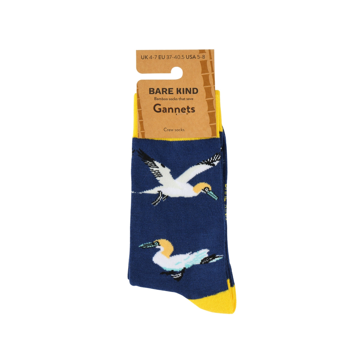 A pair of Bare Kind Gannets crew socks in navy blue with white, yellow, and black gannet bird illustrations, shown on a cardboard hanger against a white background.