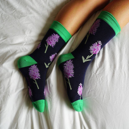 Floral-patterned socks with green accents on a white surface