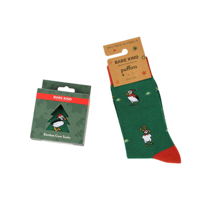 A pair of green Bare kind bamboo crew socks with puffin illustrations and red toes, shown next to their green packaging box on a white background.