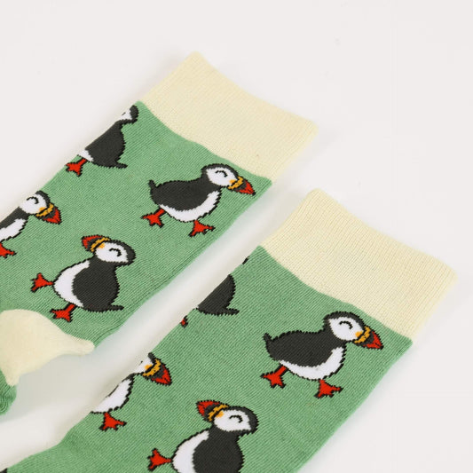 Green socks with puffin pattern on a white background