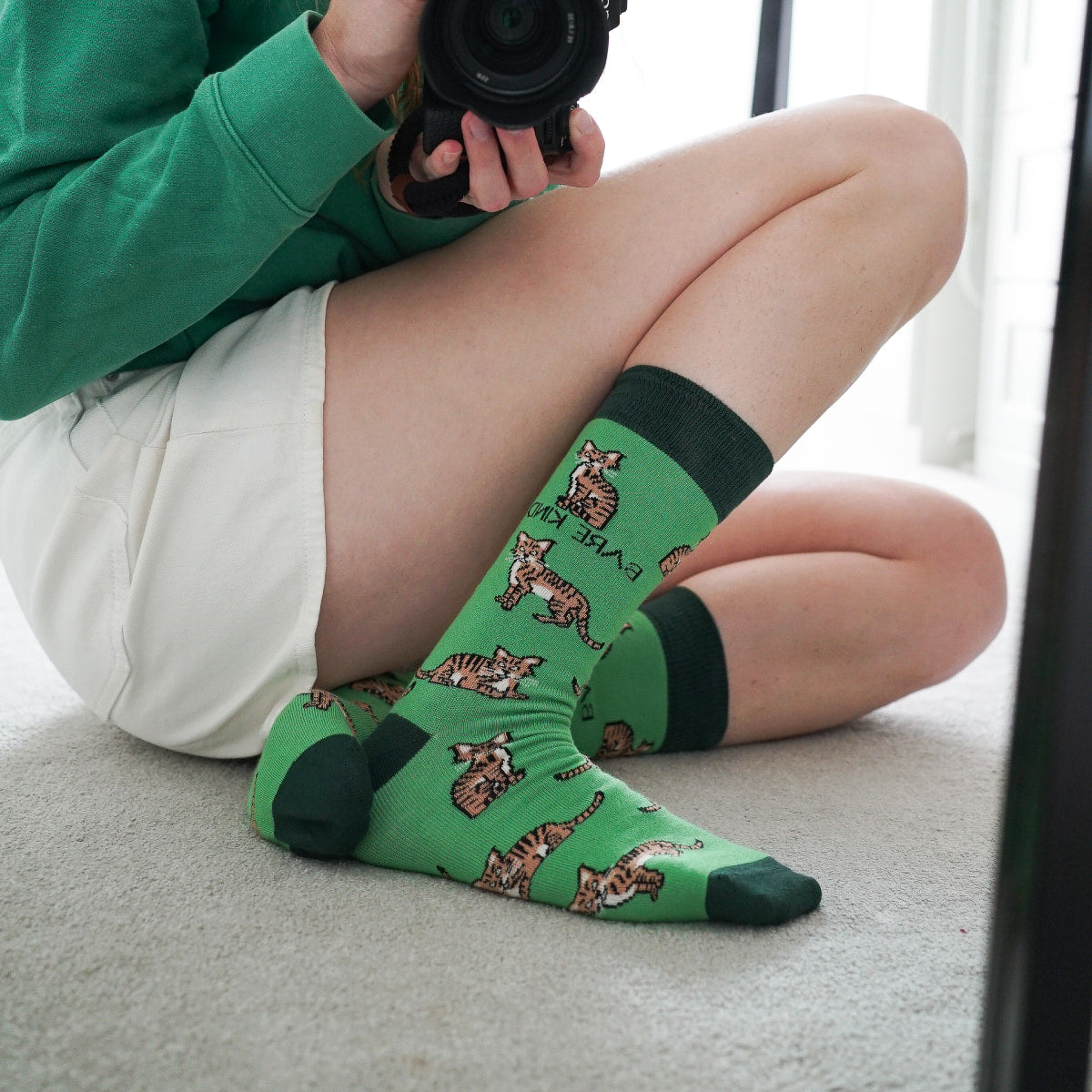 Model wearing highland wild cat bamboo socks in front of mirror