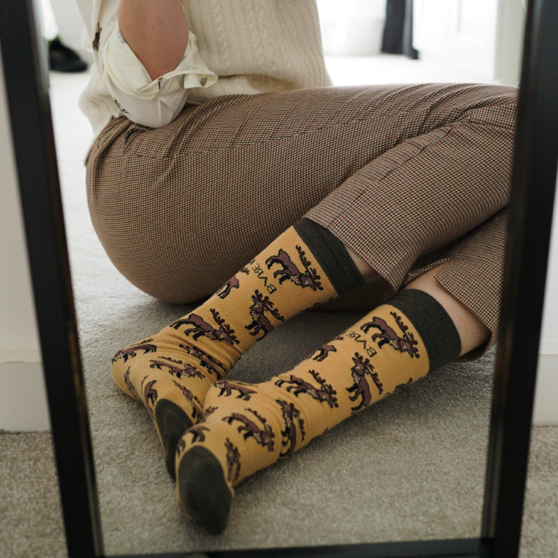 Model wearing highland deer bamboo socks in front of the mirror