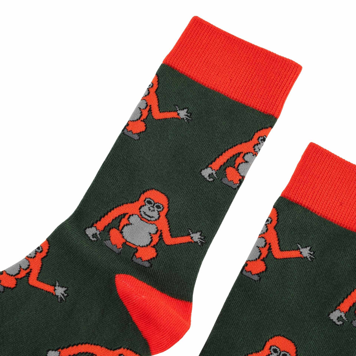 A pair of dark green crew socks with bright orange cuffs, heels, and toes, featuring a repeating pattern of orangutans in orange and gray.