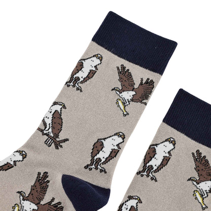 A pair of crew socks with a beige body featuring a repeating pattern of brown and white ospreys, finished with a navy blue ribbed cuff, navy toe, and navy heel.