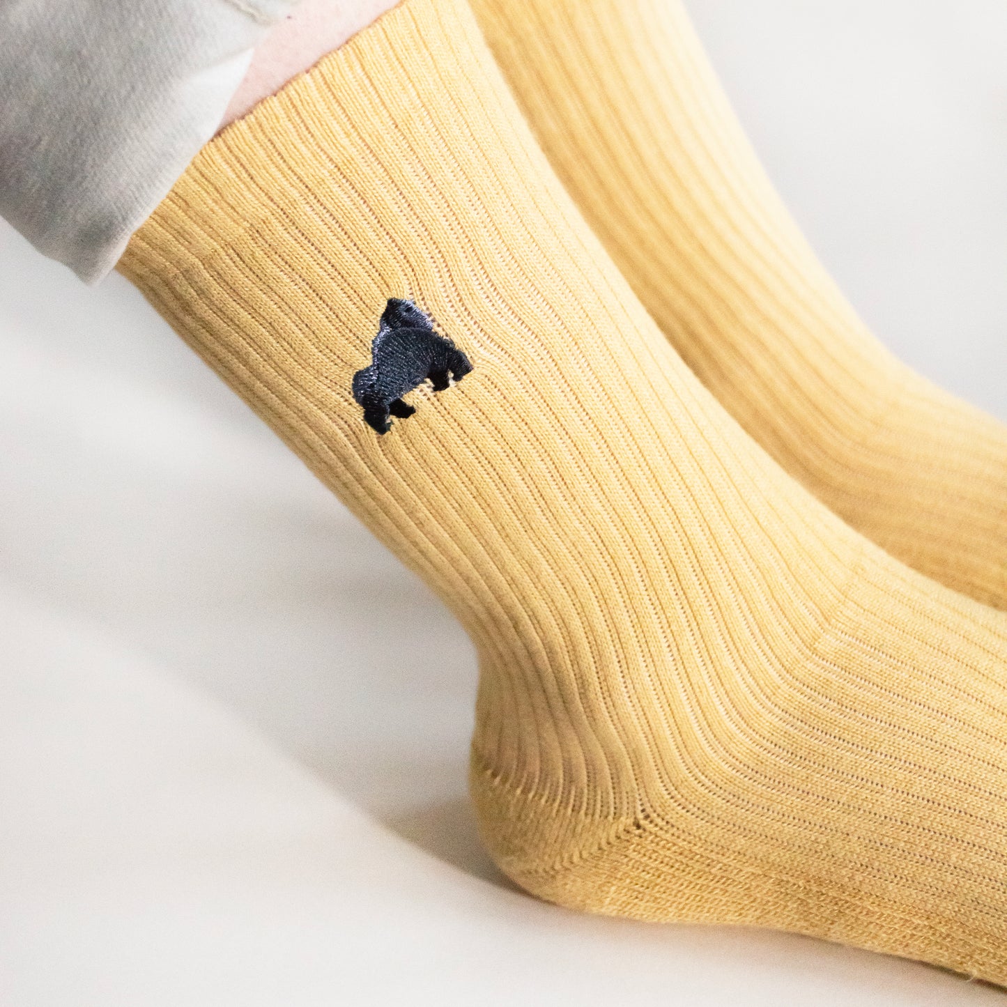 Side angle view of model wearing yellow ribbed gorilla bamboo socks