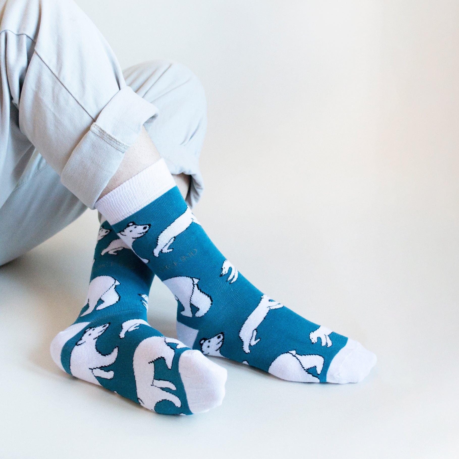 sitting model with ankles crossed wearing bamboo polar bear socks 