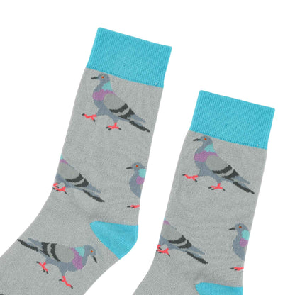A pair of gray crew socks with a repeating pattern of pigeons in shades of gray, purple, and black, featuring bright turquoise blue cuffs, heels, and toes on a white background.