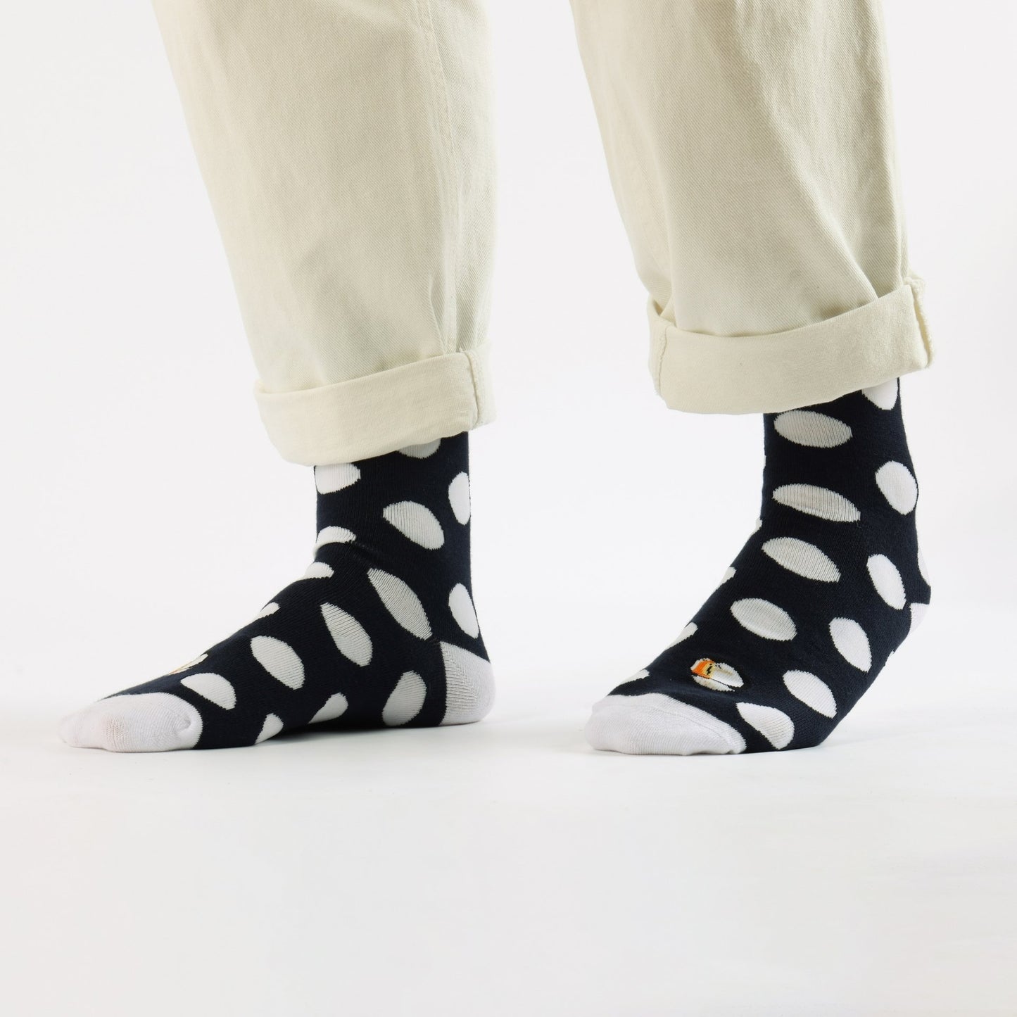 Person wearing Puffin polka dots socks on a white background