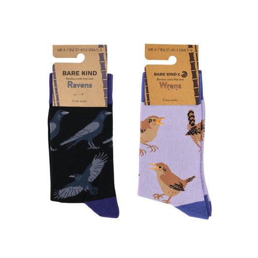Two pairs of Bare Kind bird socks on hanger cards against a white background. The left pair is black with dark blue raven prints and a dark blue toe/heel.