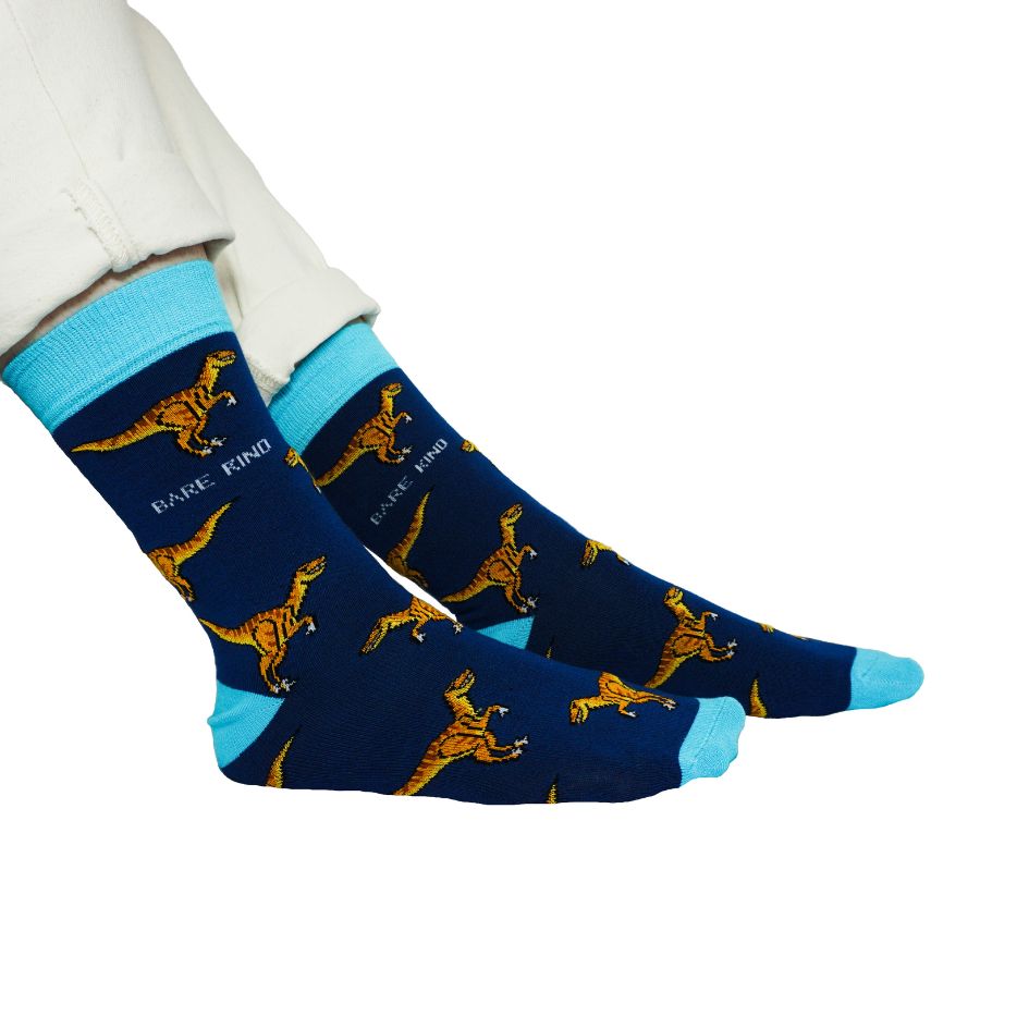 sitting model wearing blue raptor socks, side angle view