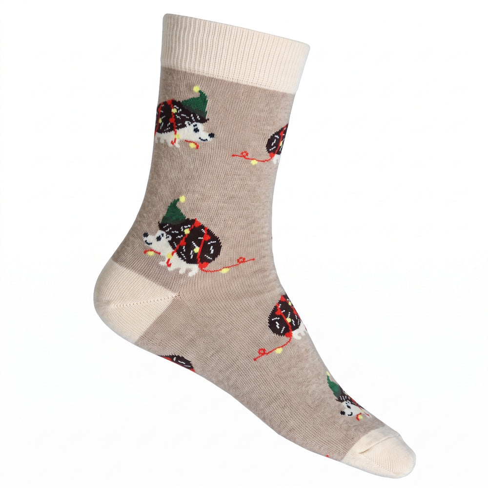 A single crew sock in warm beige with a repeating pattern of christmas hedgehogs, shown on a plain white background.