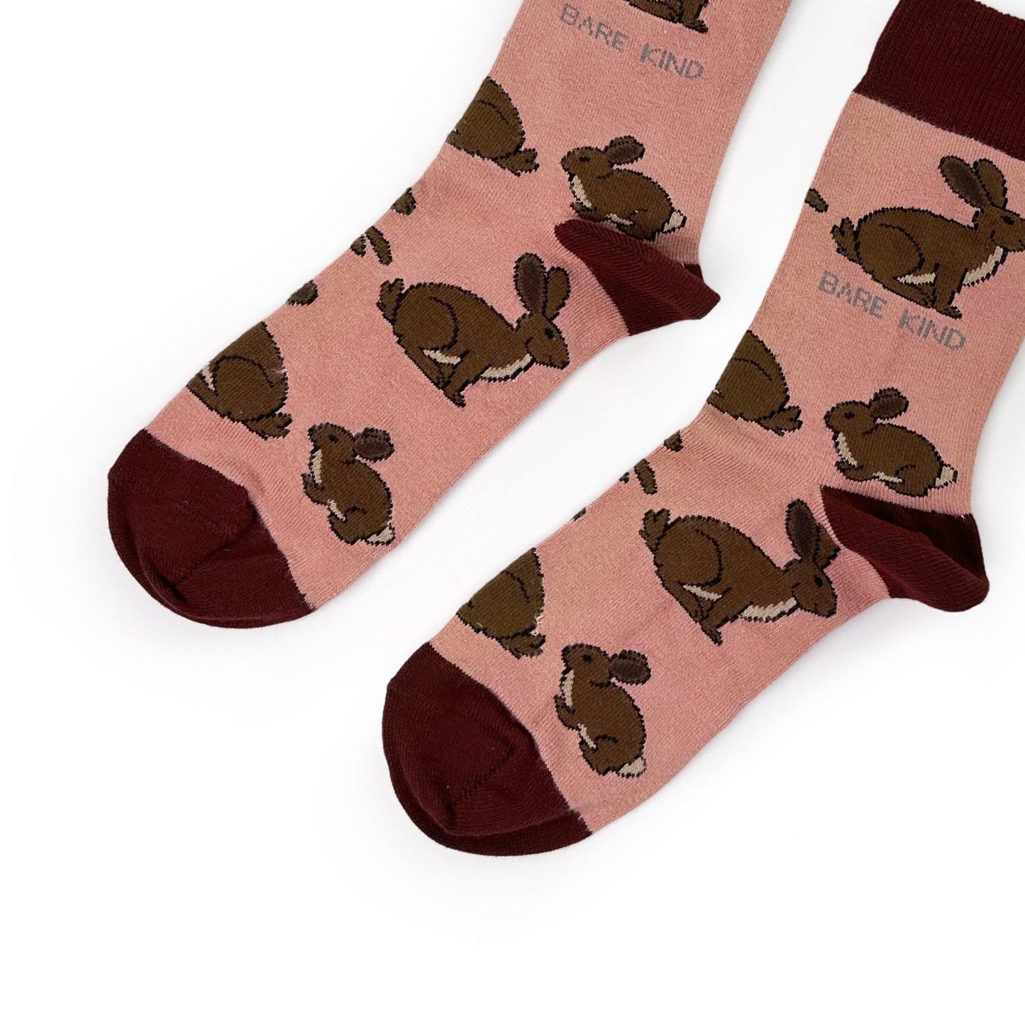 Pink socks with brown hare patterns on a white background