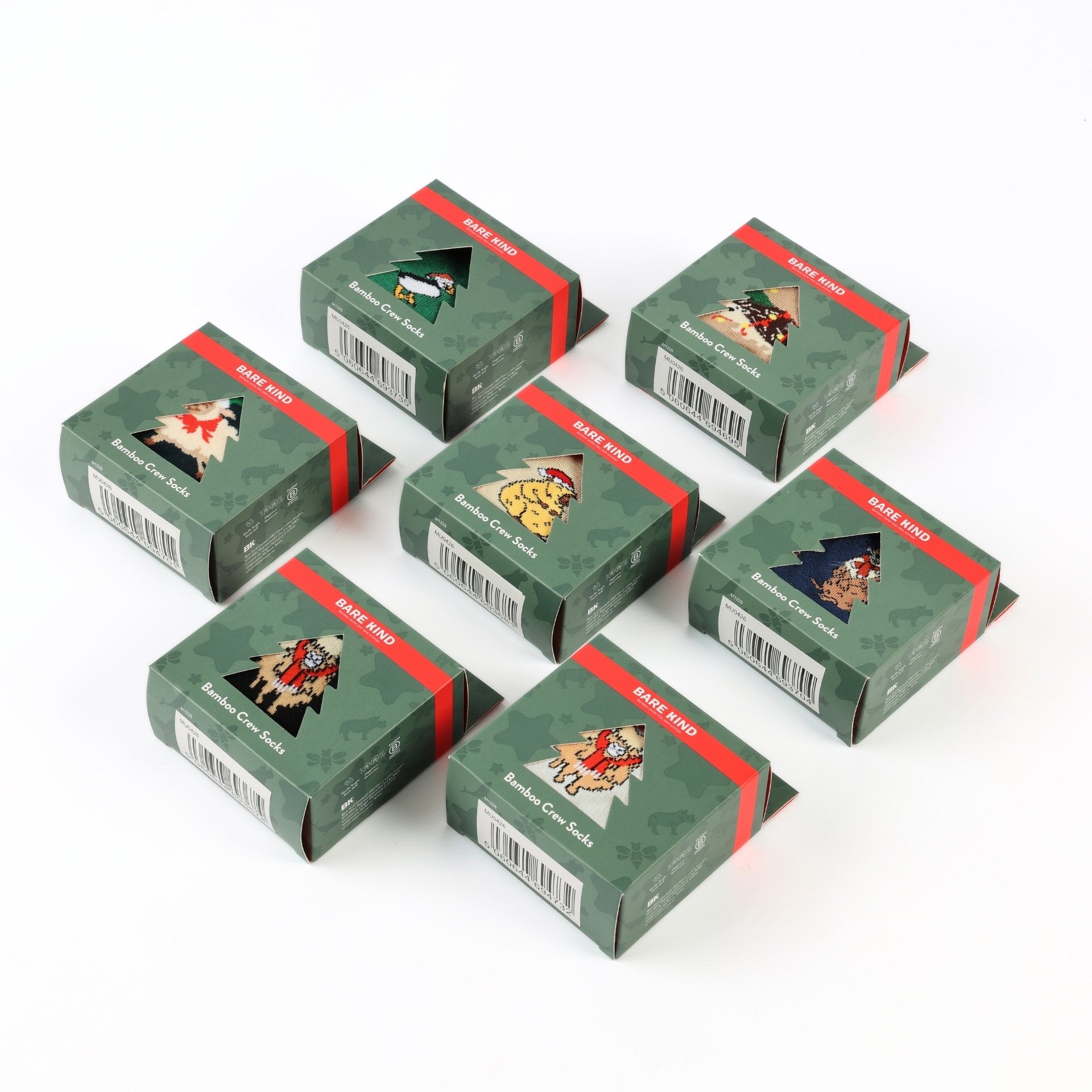 Six small green gift boxes with red bands and illustrated holiday-themed labels, arranged on a plain white background.