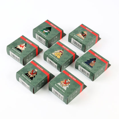 Six small green gift boxes with red bands and illustrated holiday-themed labels, arranged on a plain white background.