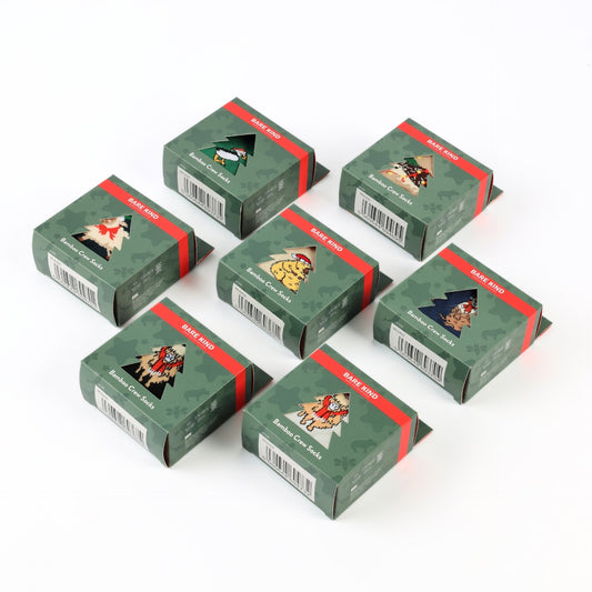 Six small green gift boxes with red bands and illustrated holiday-themed labels, arranged on a plain white background.
