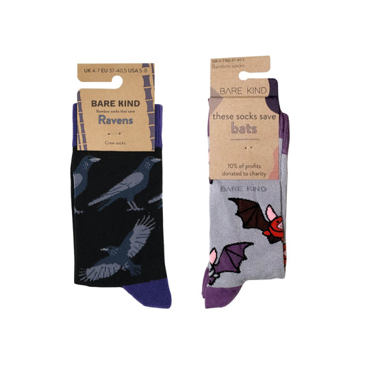 Two pairs of socks with bat and raven designs in packaging on a white background