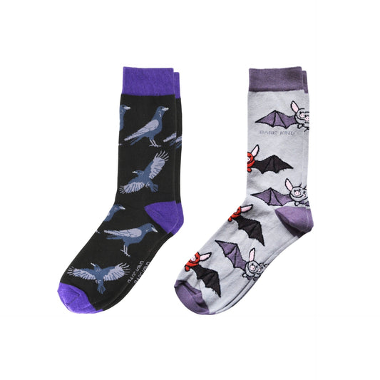 Two pairs of socks with raven and bat patterns on a white background