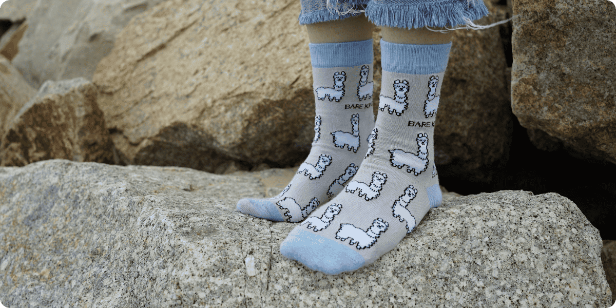 Person wearing light blue alpaca bamboo socks on rocky terrain