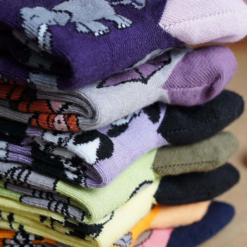 Stack of colorful socks with various patterns on a neutral background
