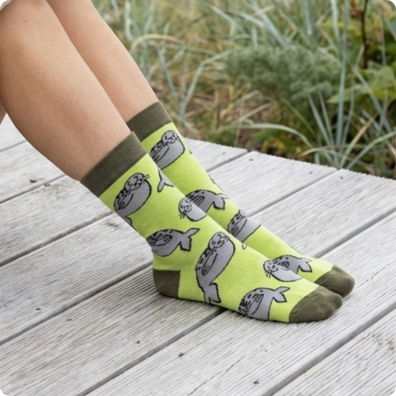 Person wearing green seal socks with on a wooden surface.