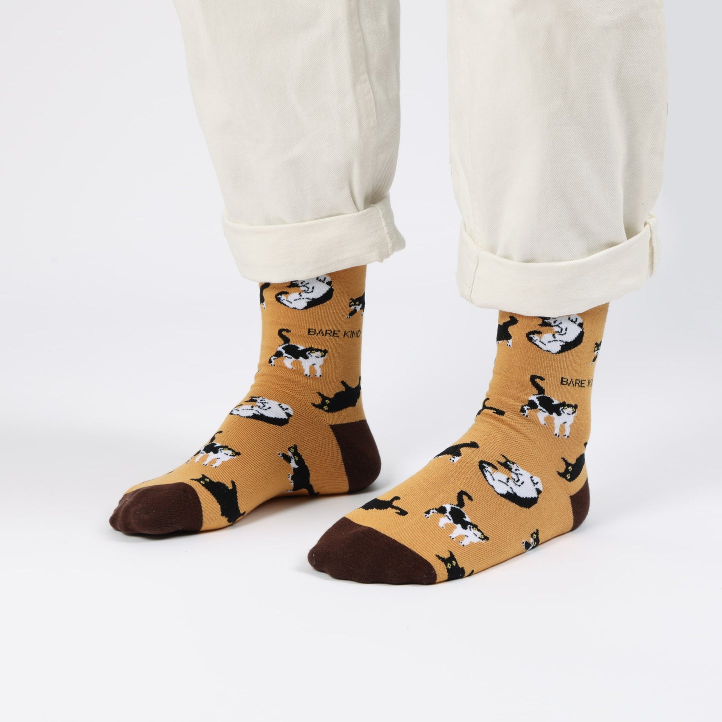 model with white trousers wearing yellow brown cat bamboo socks