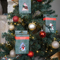 lifestyle image of cardboard christmas baubles containing christmas bamboo socks hanging on a christmas tree