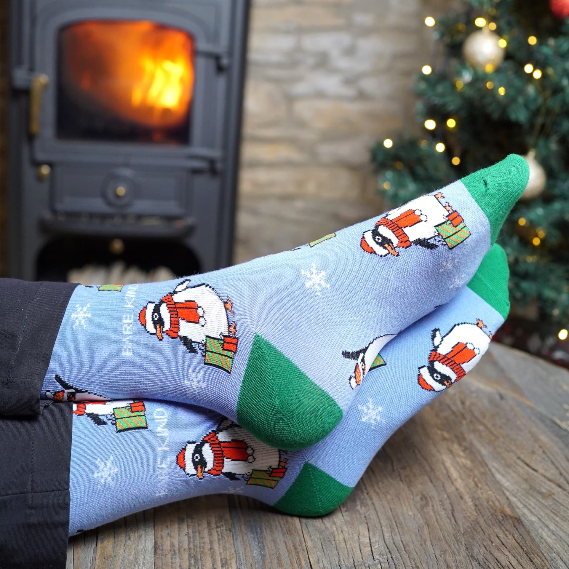 model wearing blue and green christmas penguin bamboo socks