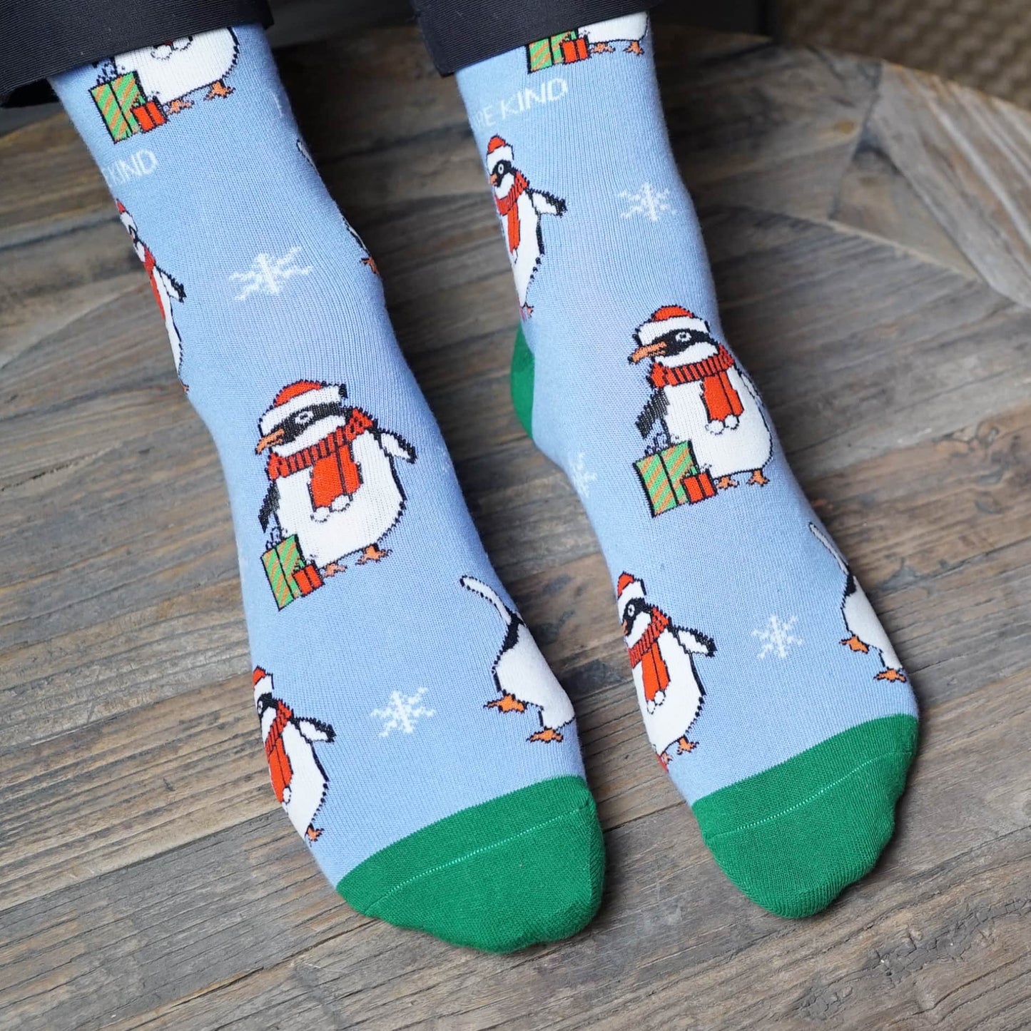 model wearing blue and green christmas penguin bamboo socks