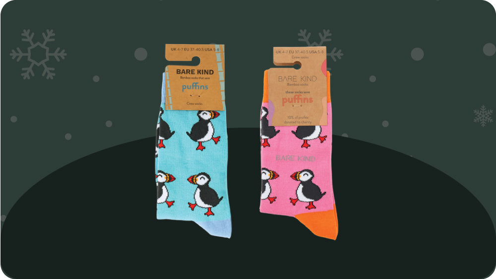 Two pairs of socks with puffin design packaging on a dark background