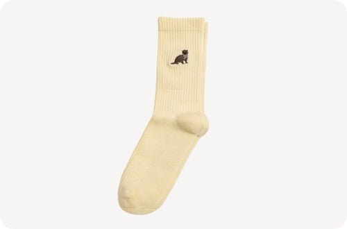 Yellow sock with a small otter design on a white background