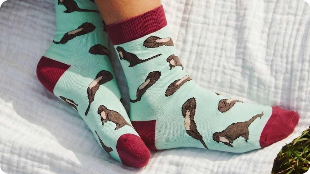 socks with brown otter pattern and red toes on a white textured surface