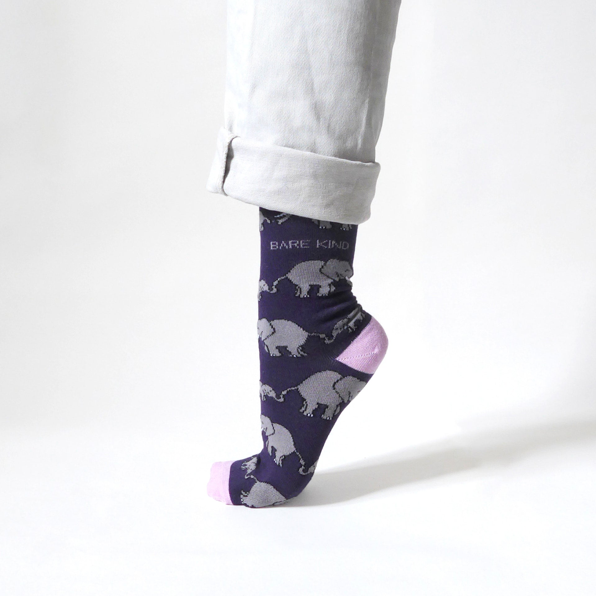 side view of standing model wearing purple and pink elephant bamboo socks